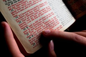 An open bible with a finger following text
